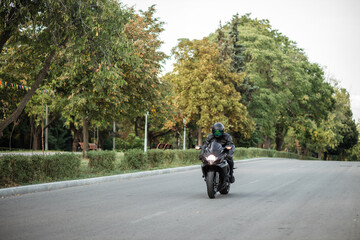 man wearing helmet riding motorcycle on open road