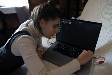 A Young Woman Diligently Working on Her Laptop in a Warm and Cozy Home Environment
