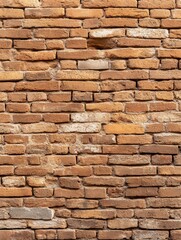Obraz premium A textured brick wall with a mix of earthy tones, showcasing an aged, rustic appearance, ideal for architectural backgrounds or construction themes.