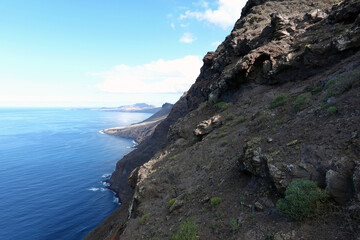 Steep mountain slope and beautiful blue Atlantic Ocean in Gran Canaria, Spain.