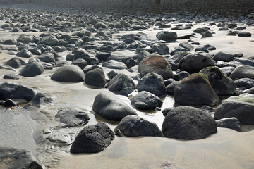 Stones on sandy beach. Low tide in Las Palmas, Gran Canaria, Spain.