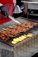 Chef Grilling Meat Skewers With Tongs