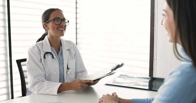 General practitioner shaking hands with woman in clinic office, accomplishing appointment at hospital. Female patient expressing gratitude and recognition for professional medical care and services