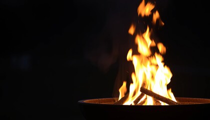 Obraz premium Fiery Campfire Burning at Night in a Dark Background