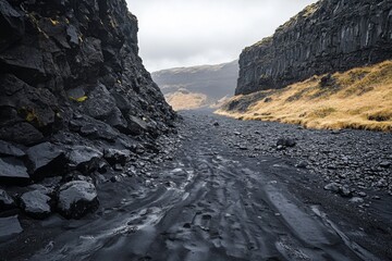 Rocky canyon with narrow river and steep cliffs under cloudy sky