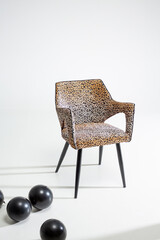 Leopard print chair on white background with black balloons
