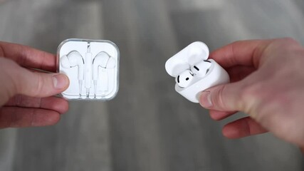 Wireless earbuds vs wired headphones closeup comparison hands holding both options highlighting tech evolution sound trends lifestyle minimalism