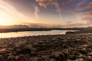 The lake of Santa Luce in the Tuscan countryside during a colorful sunrise with the typical...