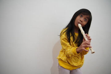 Fototapeta premium Asian girl playing recorder flute, musical instrument