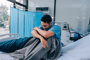 Lonely man silhouette sitting on the bed feeling depressed and stressed in the dark bedroom, Depression and anxiety disorder concept