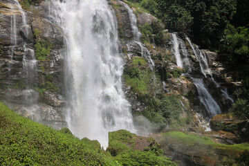 Waterfall Cascading Over Rugged and Rocky Terrain Surrounded by Natures Beauty.
