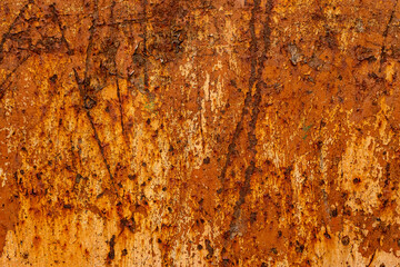 This macro photograph showcases a weathered and heavily rusted metal surface, rich in earthy tones...