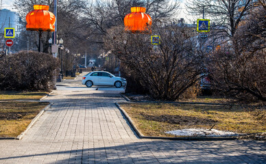 A white car on the road in the park.