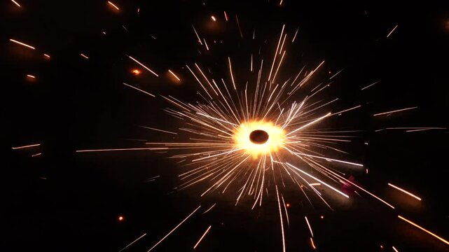 A rotating sparkler or twinkling star in the dark at night. Ground Chakkar sparkler fireworks for rolling on the ground.