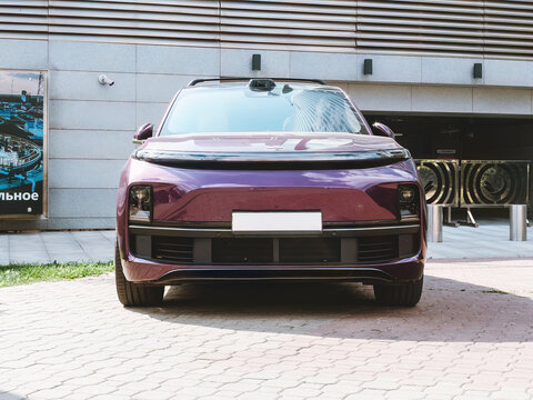 Purple full-size crossover Li L9 lixiang from Chinese manufacturer Li Auto parked against office building background