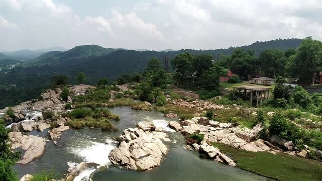 Rocks, forests, mountains, and resorts accompany the top view of the Subarnarekha River.