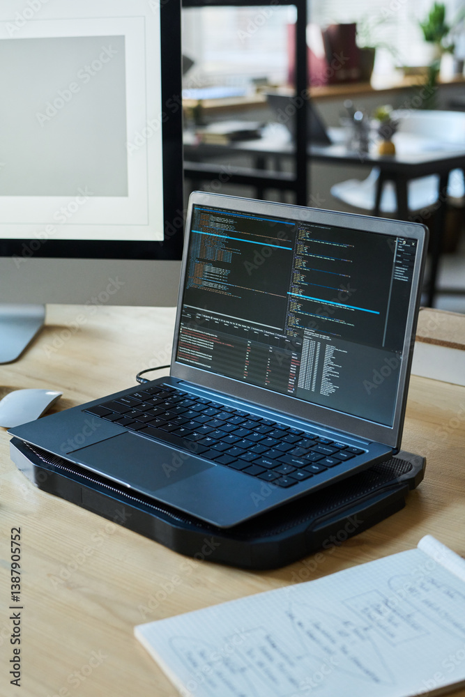 Aufkleber Laptop with coded data or new software product standing on workplace of modern programmer in coworking space