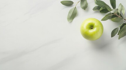 Green apple with leaves on marble background.