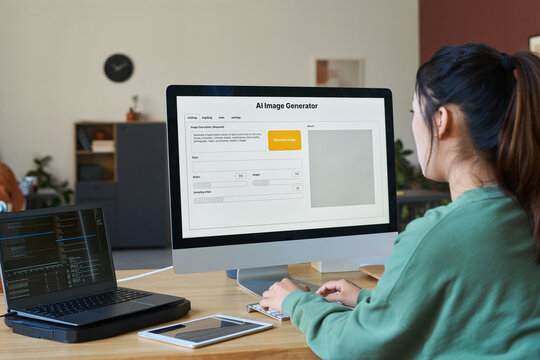 Young female designer sitting in front of desktop computer with AI image generator on screen and typing on keypad