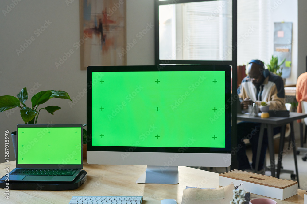 Poster Two blank chromakey screens of laptop and desktop computer standing on desk in front of camera in coworking space