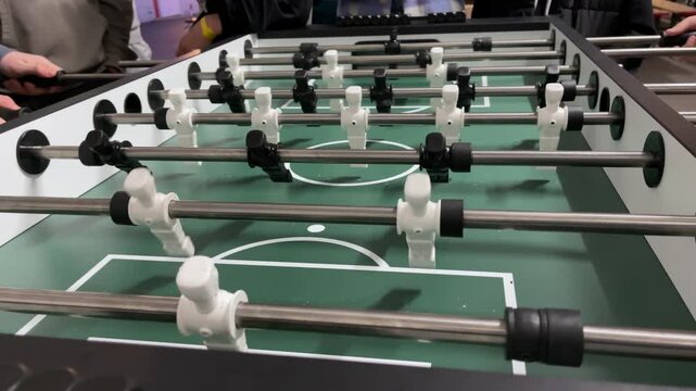 Exciting foosball shots showcasing intense gameplay featuring black and white players on a vibrant green field. The dynamic action of a foosball game, with players in constant motion and excitement