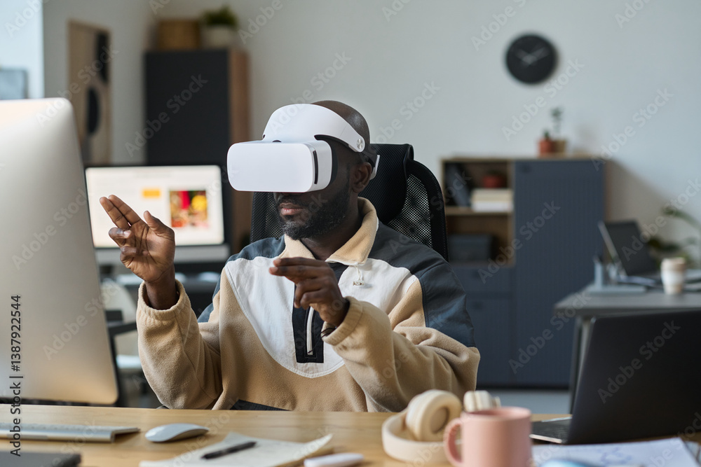 Aufkleber young modern businessman in vr headset sitting in front of desktop computer and preparing virtual pr