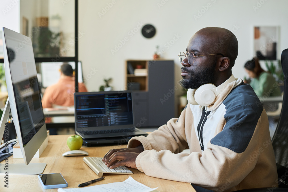 Poster Young serious man concentrating on work over new content while looking at screen of desktop computer with AI image generator