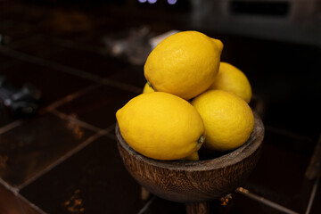 lemon and lime in wooden bowl on tiled floor