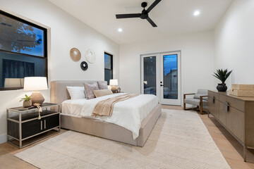 The bedroom features a spacious large bed along with a ceiling fan