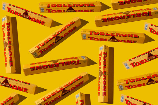 Toblerone brand chocolate packaging. Swiss Mondelez candy. Yellow pack background. Top view pattern. Ukraine, Kyiv - November 4, 2024.