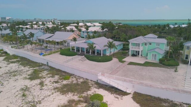 Aerial drone footage around Bimini Bahamas in the vicinity of the cruise terminal with beautiful white sand beaches and abandoned vacation houses with pools and dock.