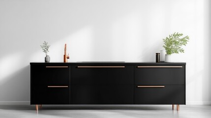 A sleek, black kitchen island features copper drawer pulls. The island sits against a minimalist white wall, adorned with small plants and d