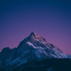 Obraz premium Craggy Snowy Mountain Glowing in Pink and Purple Light During Sunset