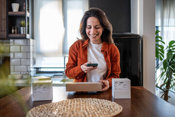 Woman managing her small business using smartphone at home
