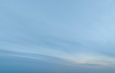 Softly blended clouds and a pastel blue sky create a serene atmosphere at dusk. The gentle gradient...