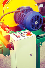 Control panel of a heavy-duty winch machine in a workshop setting showcasing industrial machinery in operation