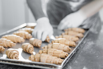 Worker preparing croissants in bakery factory with precision and care