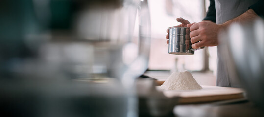 A male chef prepares dough at home in the kitchen