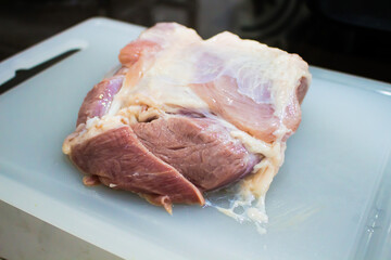 A large raw pork on a cutting board.