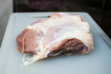 A large raw pork on a cutting board.	
