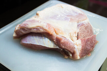 A large raw pork on a cutting board.
