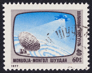 Mongolian postage stamp issued in 1977 shows a satellite transmitting to a ground antenna,...