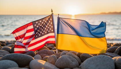 Flags of the USA and Ukraine waving in the sunset by the sea  