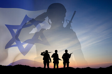 Silhouettes of soldiers against the sunset with Israel flag