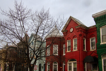 Colorful historic buildings line a street in a quaint neighborhood on an overcast day in autumn