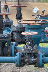 Fototapeta premium Gas Extraction Pipes with Valves in a Rural Field Setting