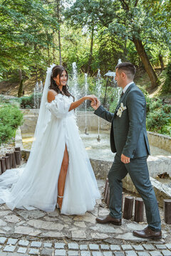 Beautiful wedding couple enjoying a peaceful moment in a scenic outdoor location. Romantic scene in natural background. Love, kiss, romance.