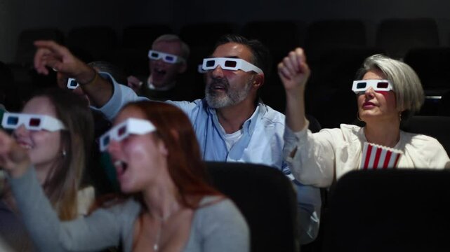 Excited audience wearing 3d glasses reacting to movie in theater