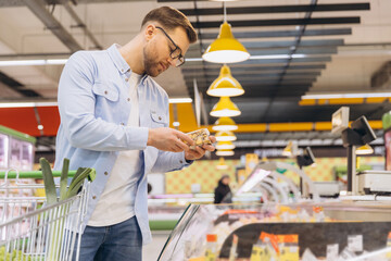 Customer choosing cheese in refrigerated section of supermarket