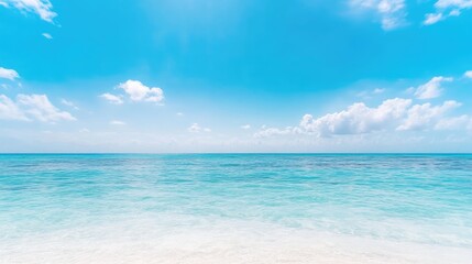 Fototapeta premium The image shows a tranquil ocean scene with calm, turquoise water meeting a white sandy beach. A vibrant blue sky filled with fluffy white clouds completes the composition. The high-resolution photo b